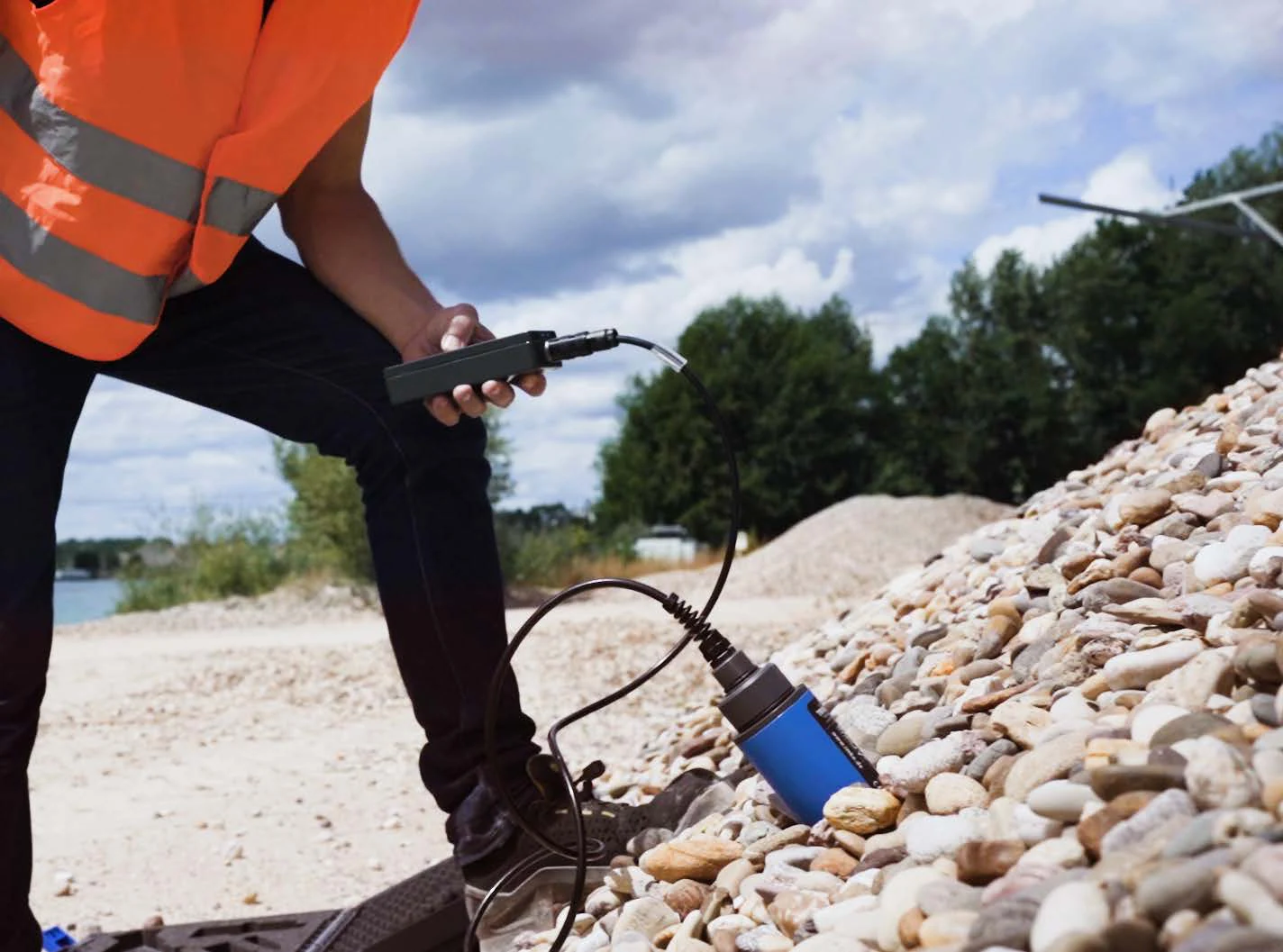 Operator taking a moisture reading at an aggregate stockpile with a portable TDR meter